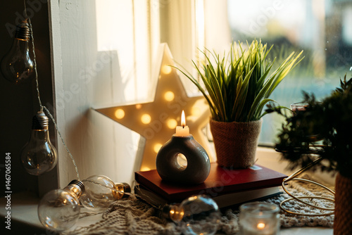 Fotografia A cozy windowsill adorned with glowing candles and elegant home decor, creating a warm and inviting atmosphere