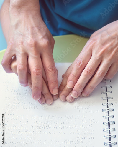 Visually impaired child reading a Braille book independently. Inclusive education and tactile learning for children with low vision or special needs. hands on braille book.