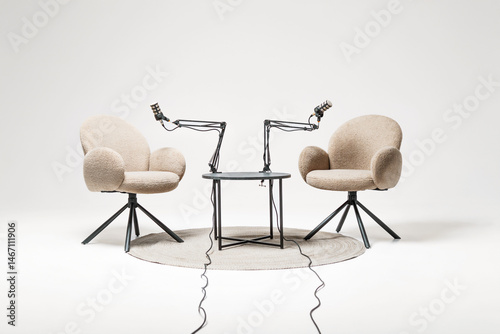 Two microphone-equipped chairs ready for podcast recording in a cozy lecture setting