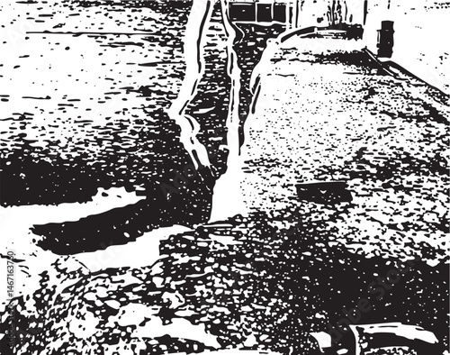 A dark puddle reflects a building’s facade in a rain-slicked street.