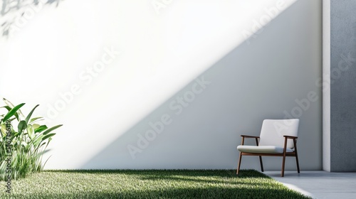 Minimalist patio with white wall, armchair, and green grass.