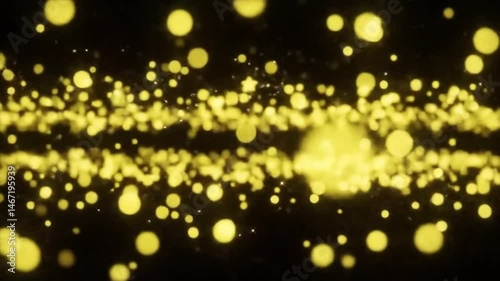 Golden bokeh lights floating and twinkling against a dark background creating a festive atmosphere