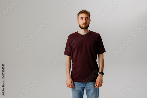 Wallpaper Mural Young man standing confidently in casual clothing against a neutral background during a studio photoshoot Torontodigital.ca