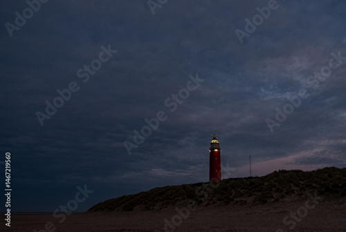 Eierland, De Cocksdorp, Texel, The Netherlands, Oktober 28th, 2024, A tranquil lighthouse stands brightly illuminated against a beautifully darkening evening sky as dusk falls