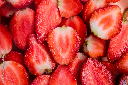 a pile of strawberries cut in half as a background