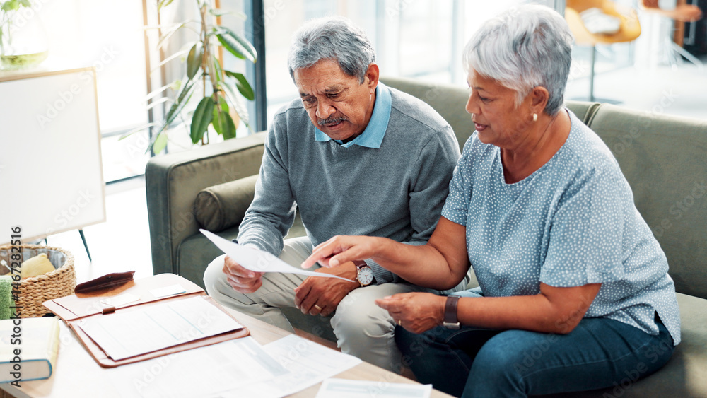 © FrameFlex/peopleimages.com - Discussion, finance documents and senior couple in home with debt, mortgage or bills with budget payment. Conversation, paperwork and elderly man with woman for planning retirement account in house.