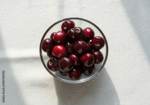 Obraz na płótnie Bowl of fresh dark red cherries on sunlit table w salonie