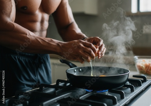 Obraz na płótnie Fit young adult cracking eggs into frying pan on kitchen stove w salonie