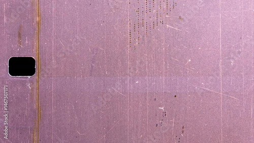 Old scratched film showing rectangular hole on black background
