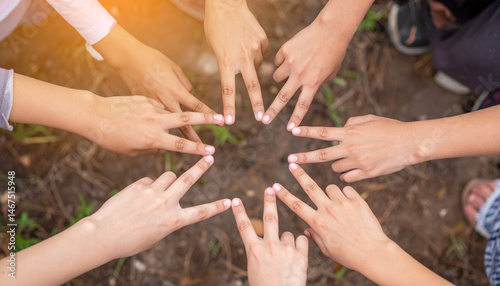 Close-up top view of a group of diverse children's hands forming a star shape 