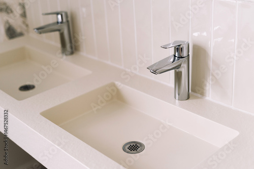 Bright and airy bathroom showcases two modern sinks with polished chrome faucets