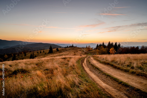 Fototapeta Naklejka Na Ścianę i Meble -  Picturesque road in the mountains. Path among colorful meadows and fields. Autumn landscape of Polish hills.