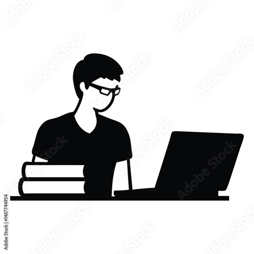 Man with glasses and books works attentively on his laptop device