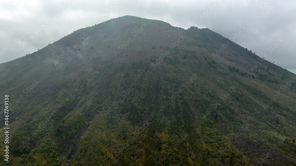Fototapeta premium Aerial view of the summit of the Vesuvius volcano, in Campania, Italy. It is an active stratovolcano in a quiescent state. It's a rainy and cloudy day.
