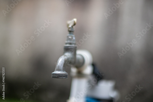 Metal water tap with soft focus background