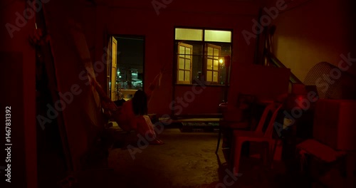 Horror scene of a mysterious Scary Asian ghost woman creepy have hair covering the face sitting on a swing at abandoned house with dark scene movie at night, festival Halloween concept