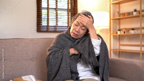 Video 4K Resolution of Senior elderly patient sneezing coughing and pain, flu or sickness with cold or illness in living room