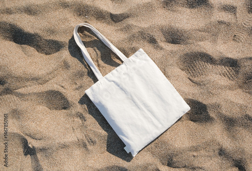 White cotton or mesh bag on beach sand background