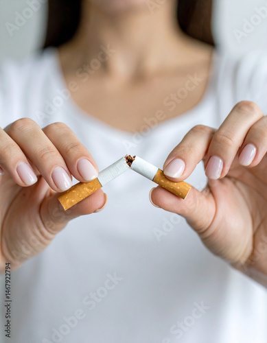 Close-up of a woman's hands breaking a cigarette, symbolizing quitting smoking, personal health choice, emotional strength, and support for World No Tobacco Day and tobacco prevention campaigns.

