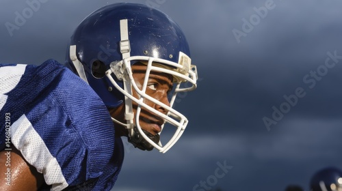 Focused Football Player Intense Look Under Ominous Sky Ready For Action On The Field Portrait View