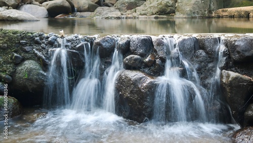 Konstfotografi A gentle or low-height waterfall where water flows over rocks or a short drop
