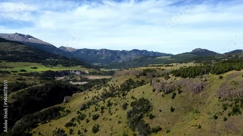 Vista aérea del río Coyhaique rodeado de árboles y montañas verdes en la inmensidad patagónica.