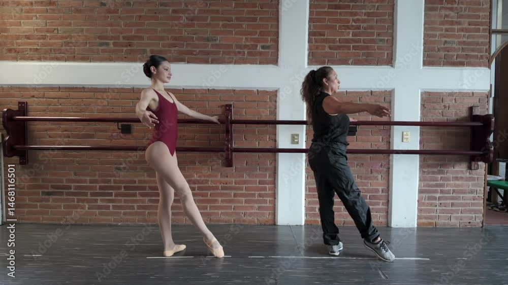 Ballet rond de jambe at barre with student and teacher in dance studio