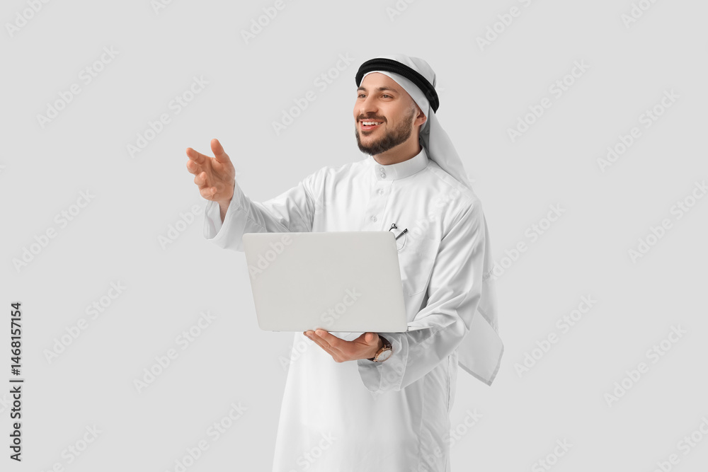 Arab businessman with laptop on light background Arab businessman with laptop on light background