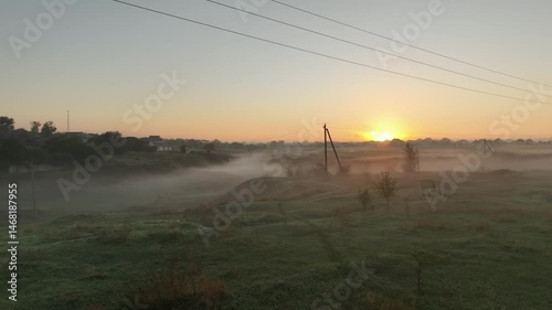 morning in the fog Epic Aerial Flight. Village looks mesmerizing at dawn, with buildings bathing in morning sunlight, forming a breathtaking scape silhouette visible from above.