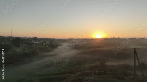 Epic Aerial Flight. Village looks mesmerizing at dawn, with buildings bathing in morning sunlight, forming a breathtaking scape silhouette visible from above.