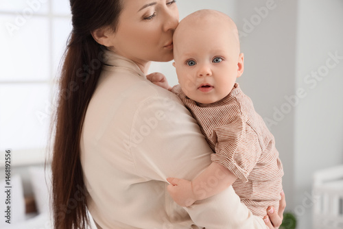 Happy mother kissing her li...