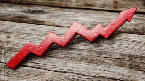 Red zig zagging arrow pointing upwards towards progress on weathered wooden surface suggesting trends and positive development