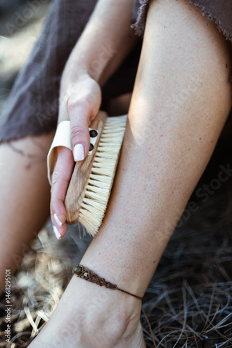 Close-Up of a Woman Exfoliating Her Leg with a Natural Bristle Body Brush Outdoors