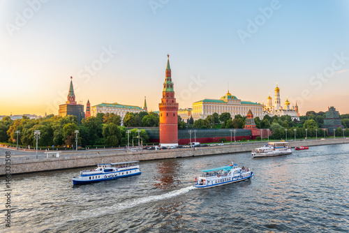 View of Kremlin with Vodovzvodnaya tower, Grand Kremlin Palace from repaired Bolshoy Kamenny Bridge in Moscow city on sunny summer day. Cruise ship sails on the Moscow river