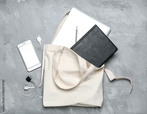 Wallpaper Mural Flat lay of laptop, notebook, phone, and chargers in a tote bag on a gray background. Perfect for blogs, websites, and social media. Torontodigital.ca