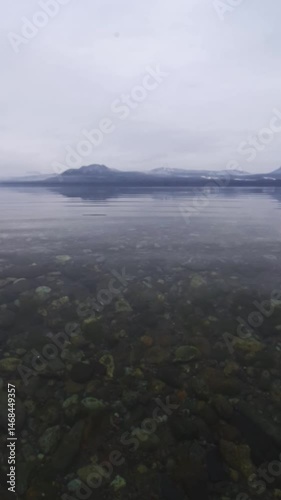曇った朝の透明な水の湖と山の穏やかな風景。