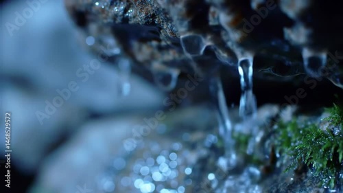 Gentle cascades: Crystal water dripping from mossy rocks, tranquil nature scene