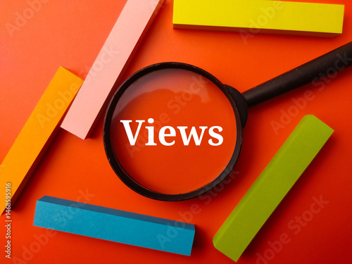 Magnifying glass and coloful sticky note with the word Views on a orange background