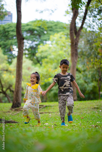 Adorable kid boy and girl enjoy run on greeen meadow grass city park
