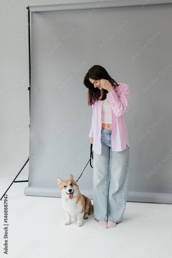 Young woman in jeans and shirt with dog on white background. Dog is man's friend. Pet love concept.