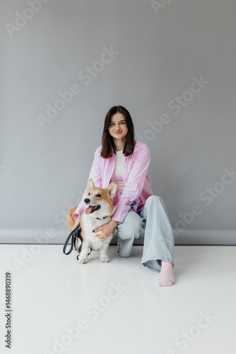 Obraz na płótnie Young woman in jeans and shirt with dog on white background. Dog is man's friend. Pet love concept. w salonie