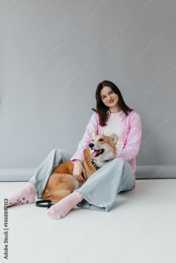 Young woman in jeans and shirt with dog on white background. Dog is man's friend. Pet love concept.