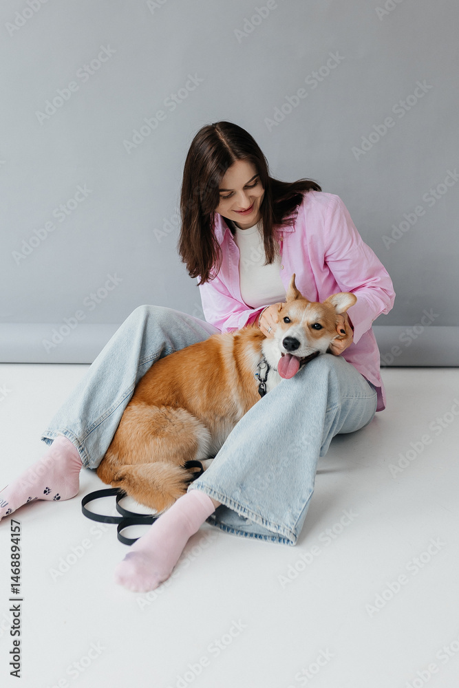 Young woman in jeans and shirt with dog on white background. Dog is man's friend. Pet love concept.