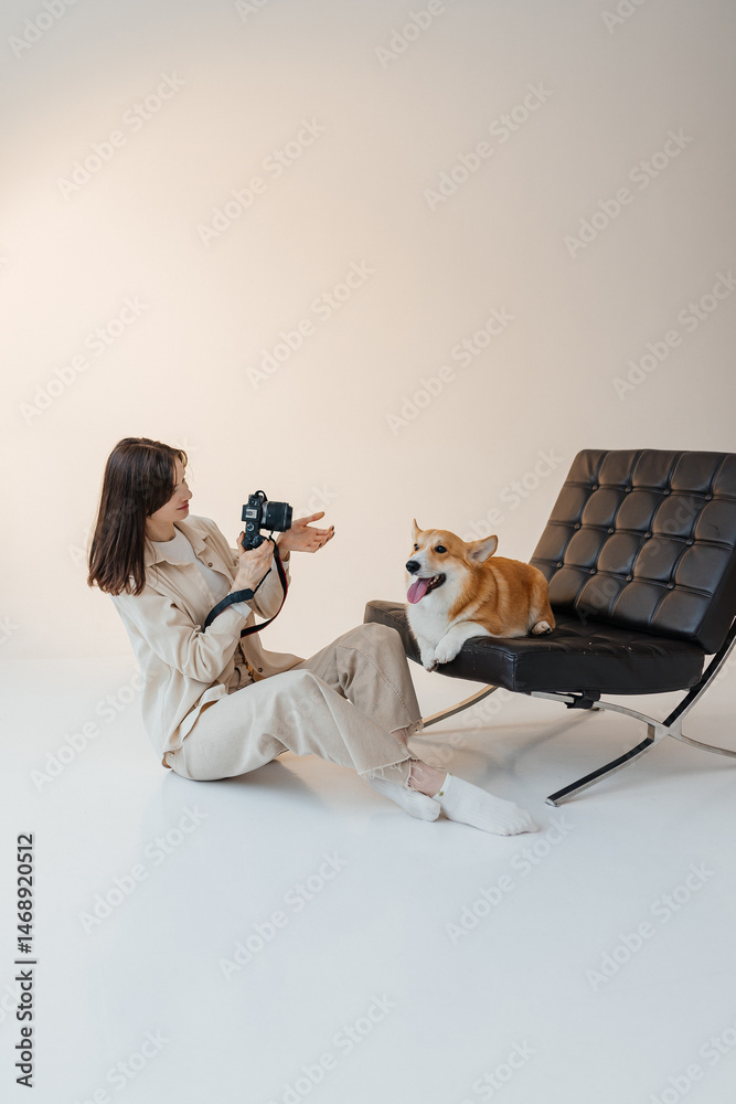 Young woman playing with her corgi dog. Healthy lifestyle and living in an apartment with a pet. Pets concept.