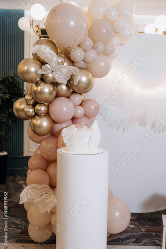 Obraz na płótnie White cake for celebrating a child's baptism. Sweet cake with white wings. Photo zone for a child's baptism. w salonie