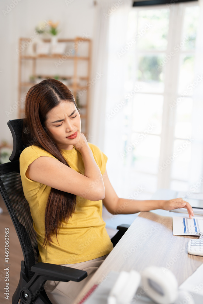 Young woman suffering from neck ache after working with laptop computer in bad posture sitting at desk. Massage for painful backache at home . Tired people overwork . Young woman suffering from neck ache after working with laptop computer in bad posture sitting at desk. Massage for painful backache at home . Tired people overwork .