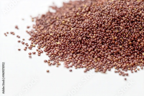 Close-up of red quinoa grains scattered on white background
