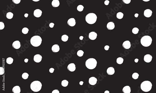 Hand drawn dotted seamless pattern in grungy style. rough organic hand drawn polka pattern in white color on dark background.