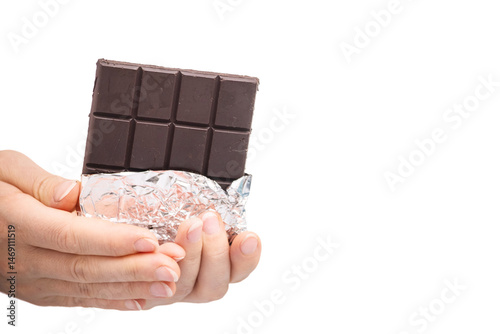 a bar of delicious chocolate in a woman's hand on a light background.