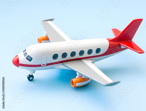 Red and white toy airplane on light blue background symbolizing travel